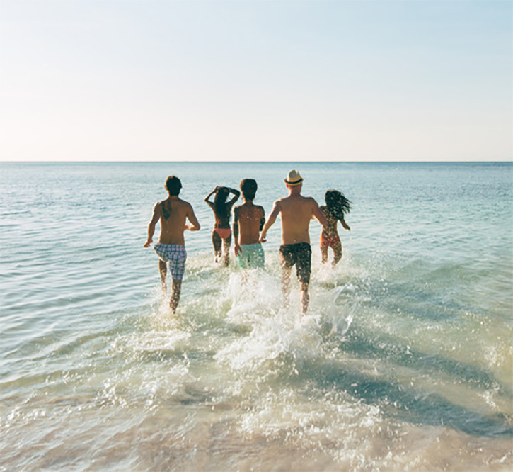 Friends running into the water together at Delray Beach